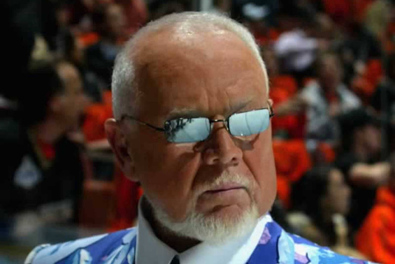 A close up of Don Cherry wearing mirrored sunglasses, high suit collar and a blue and white flower blazer.